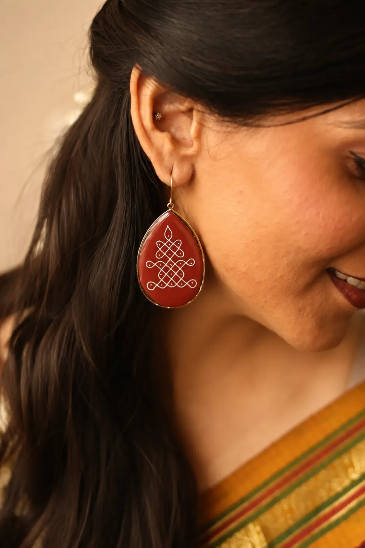 A model wearing an Alankaara kolam resin earring